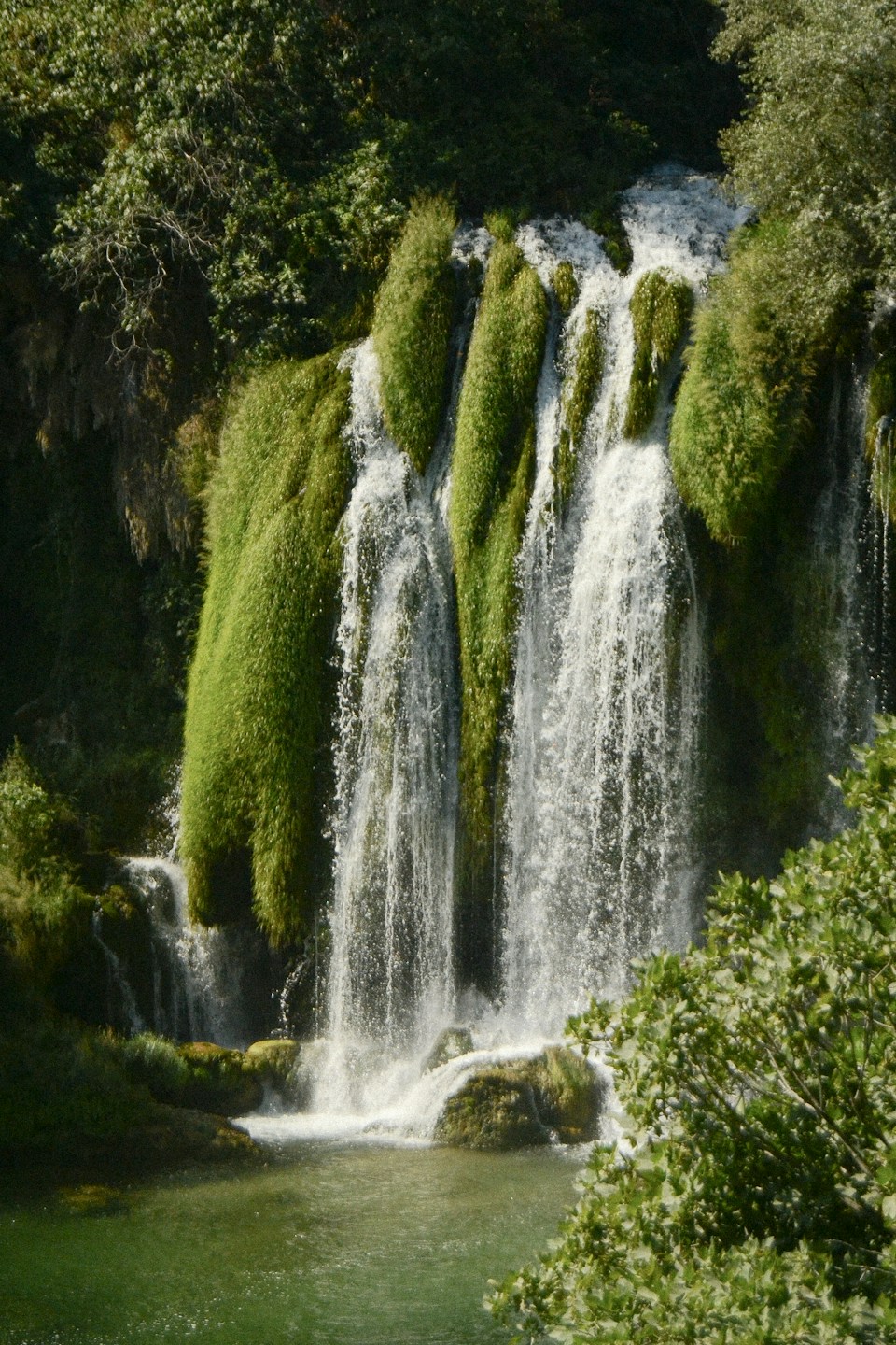 Voda se spušta preko zelenih stijena vodopada Kravice